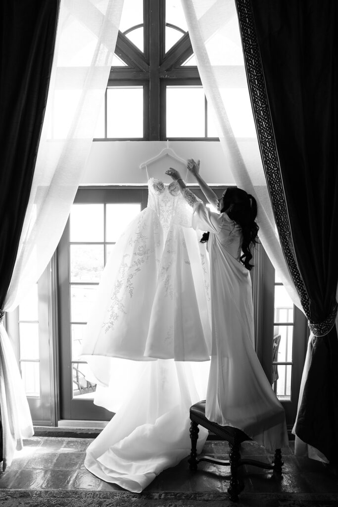 Braut-richtet-ihr-Hochzeitskleid-am-Fenster